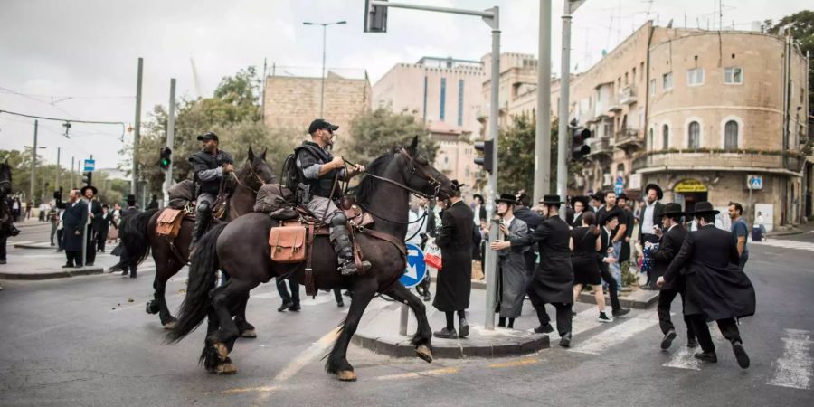 Berittene Mitglieder der israelischen Sicherheitskräfte versuchen, die Demonstranten zu zerstreuen.