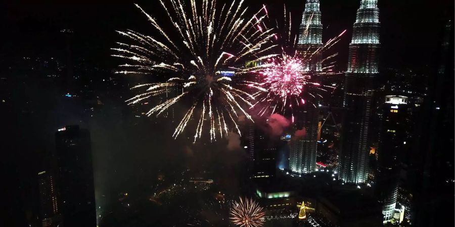 Raketen explodieren beim Feuerwerk über Kuala Lumpur (MYS).