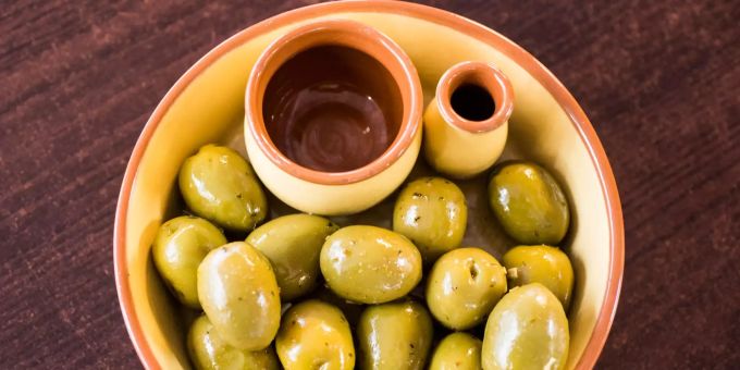 Die EU geht gegen die US-Sonderzölle auf spanische Oliven vor. In einer Schale liegen eingelegte grüne Oliven aus Spanien.