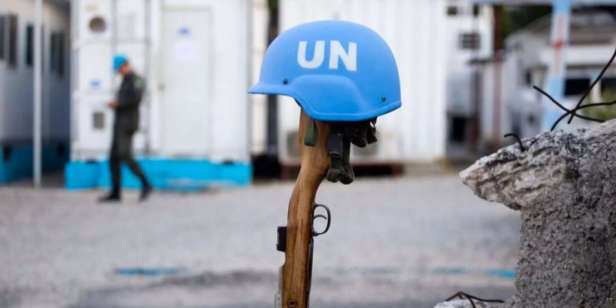 Ein Blauhelm auf einem Gewehr in Haiti.