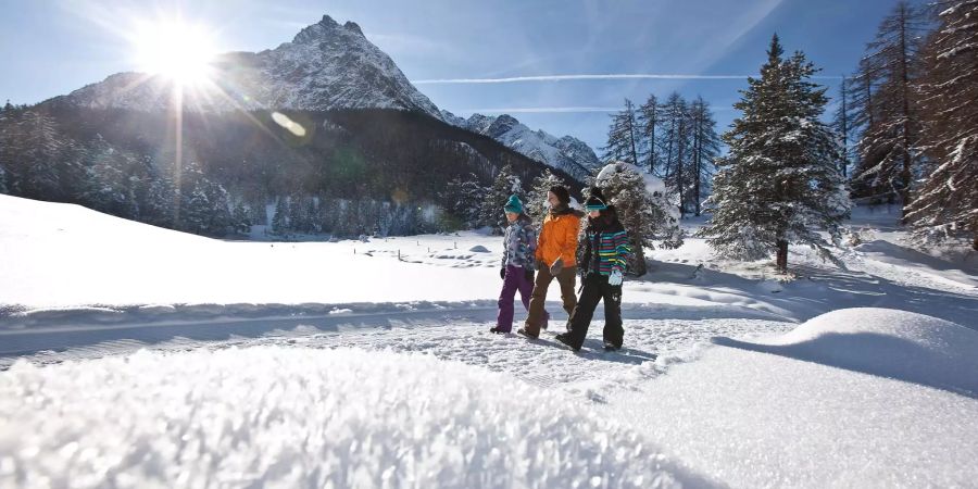 Kinder im Engadin laufen im Schnee.