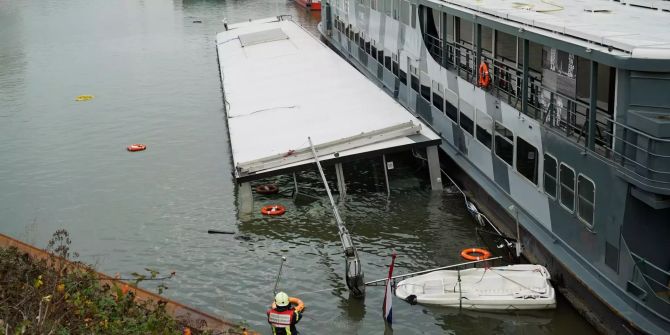 Ein Partyschiff (r) liegt neben einem gesunkenen (M) im Hafen Niehl.