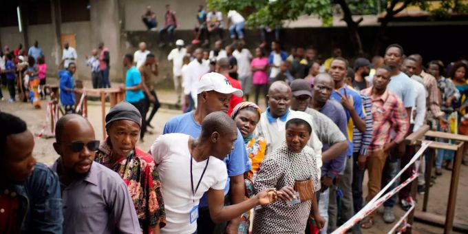 Wähler warten vor der St. Raphael Schule in Kinshasa, um dort in einem Wahllokal ihre Stimme abzugeben. Wähler stehen Schlange