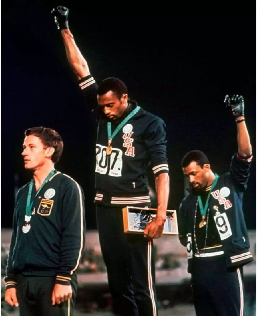 US-Sprinter Tommie Smith mit der Handschuh-Geste in der Mitte an den Olympischen Spielen 1968.