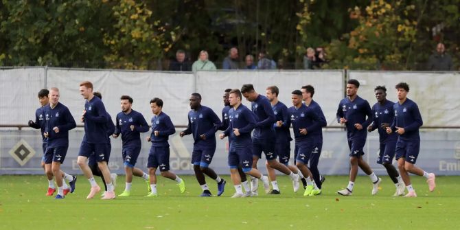 Die erste Mannschaft des HSV läuft sich vor einem Training ein.