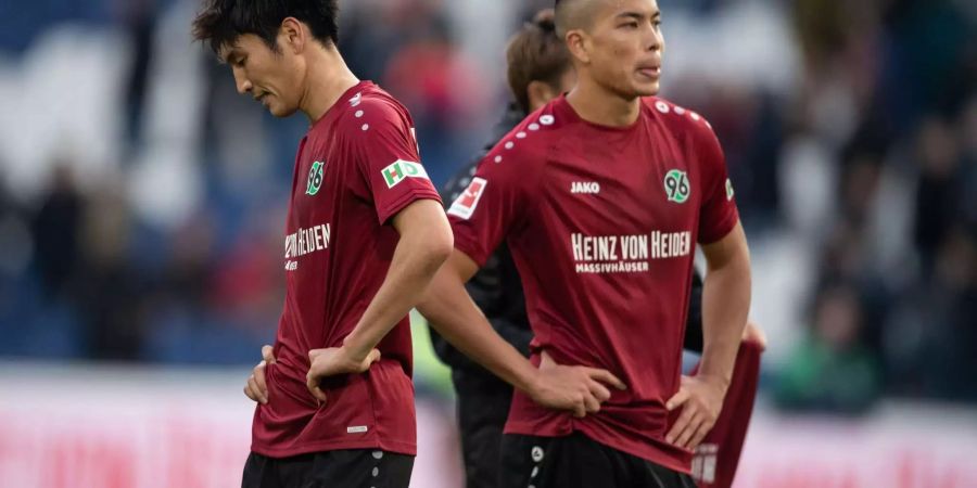 Hannovers Genki Haraguchi (l) und Bobby Wood stehen nach dem Spiel auf dem Platz.