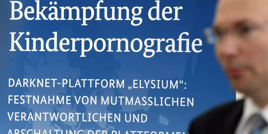 Einem Plakat mit der Überschrift «Bekämpfung der Kinderpornografie» wird während einer Pressekonferenz zur Schau gestellt.