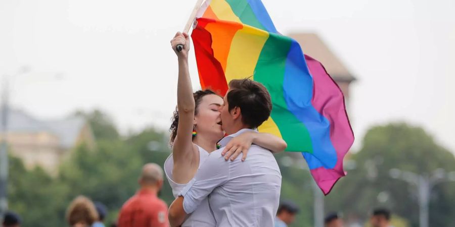 Zwei Frauen küssen sich und halten eine Regenbogen-Fahne während der Gay-Pride-Parade in Bukarest.