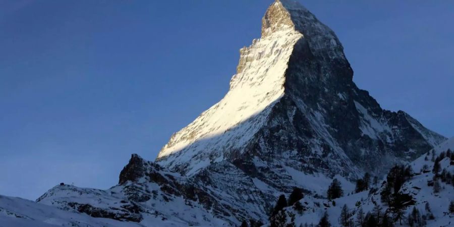 Die aufsteigende Sonne beleuchtet das Matterhorn, aufgenommen von Zermatt VS.