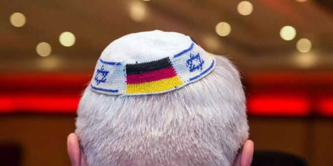Ein Mann trägt eine Kippa mit eingearbeiteten israelischen und deutschen Fahnen. Ein Mann trägt eine Kippa mit eingearbeiteten israelischen und deutschen Fahnen.