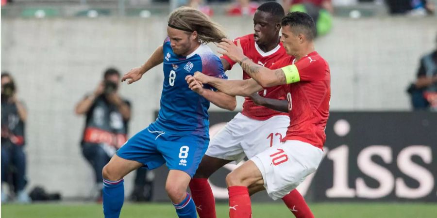 Granit Xhaka und Denis Zakaria versuchen Birkir Bjarnason den Ball abzunehmen.