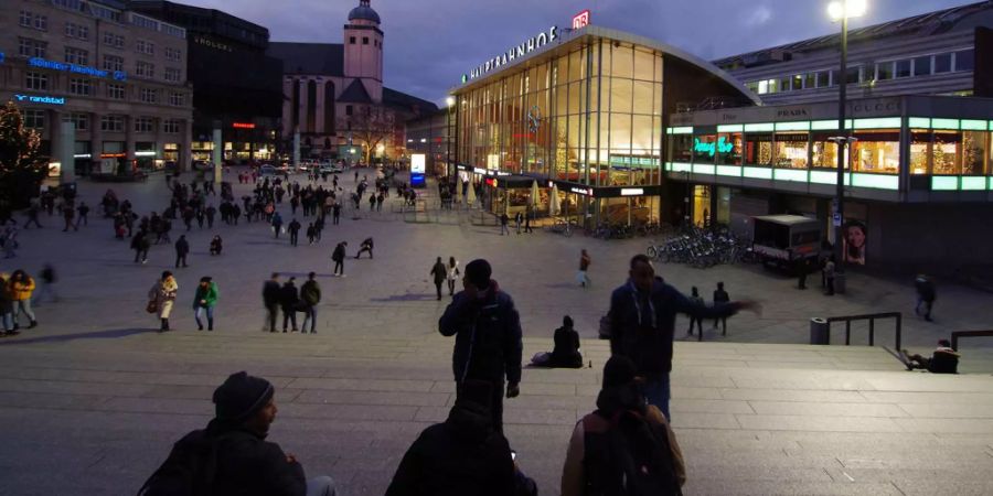 Junge Migranten sitzen am 25.12.2017 auf einer Treppe vor dem Hauptbahnhof in Köln (Nordrhein-Westfalen). In der Silvesternacht 2015/2016 waren Frauen auf dem Bahnhofsvorplatz massenhaft sexuell bedrängt und teils beraubt worden - überwiegend von Gruppen alkoholisierter junger Männer aus Maghreb-Staaten.