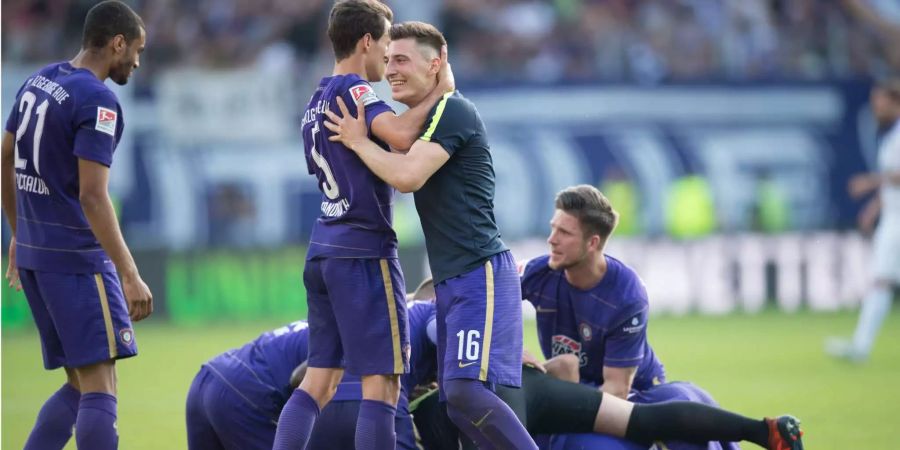 Die Spieler von Erzgebirge Aue feiern den Klassenerhalt.