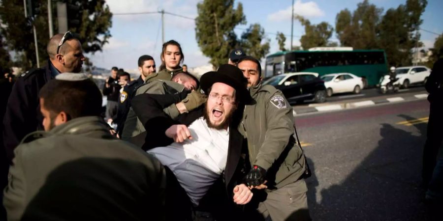 Ein orthodoxer Mann protestiert gegen die Rekrutierung von streng religiösen Männern.