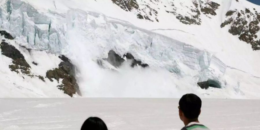 Touristen beobachten einen Gletscherabbruch beim Jungfraujoch.