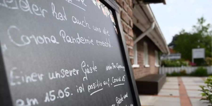 Ein Schild mit der Aufschrift «Leider hat auch uns die Corona Pandemie erreicht», steht vor dem Restaurant «Alte Scheune» in Moormerland. Foto: Lars-Josef Klemmer/dpa
