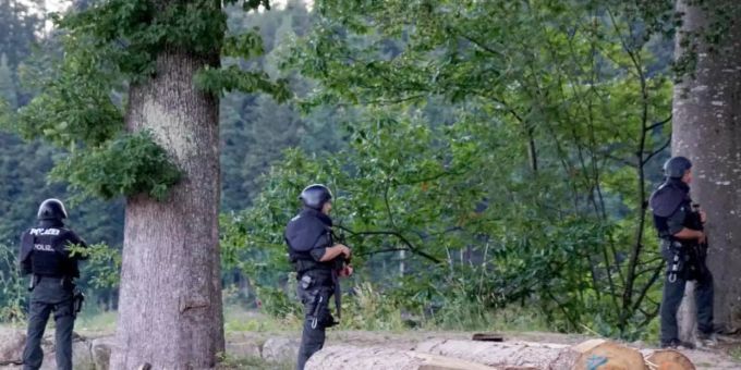 Polizisten stehen vor einem Waldstück an einer Strasse bei Oppenau. Am Vortag hatte ein Mann bei einer Kontrolle Polizisten bedroht und entwaffnet. Oppenau Schwarzwald