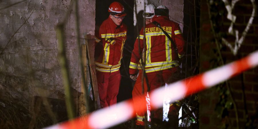 Rettungskräfte beraten vor eine Gebäude, in dem sich Personen in einem Tunnel verschanzt haben.