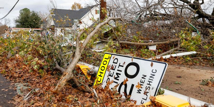 Ein Schild für eine Geschwindigkeitsbegrenzung in einer Schulzone liegt zusammen mit umgestürzten Bäumen nach einem Tornado auf dem Boden. (Archivbild)