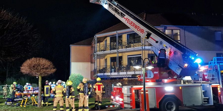 Feuerwehrleute sind am Abend vor dem Heim in Kamen im Einsatz.