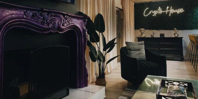 In dem Krypto-Haus findet sich ein violett-metallischer Kamin und eine passende Leuchtschrift. krypto haus hollywood