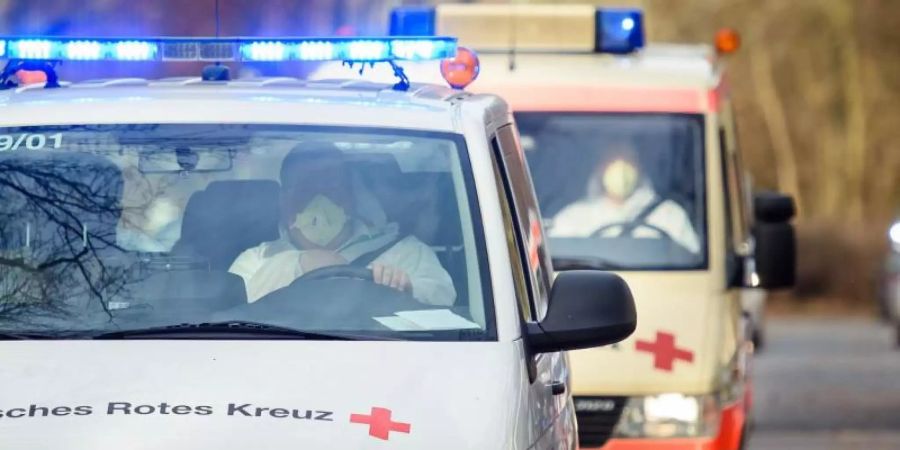 Fahrzeuge des Deutschen Roten Kreuzes fahren unter Polizeischutz auf das Gelände der DRK Kliniken Berlin-Köpenick. Foto: Gregor Fischer/dpa