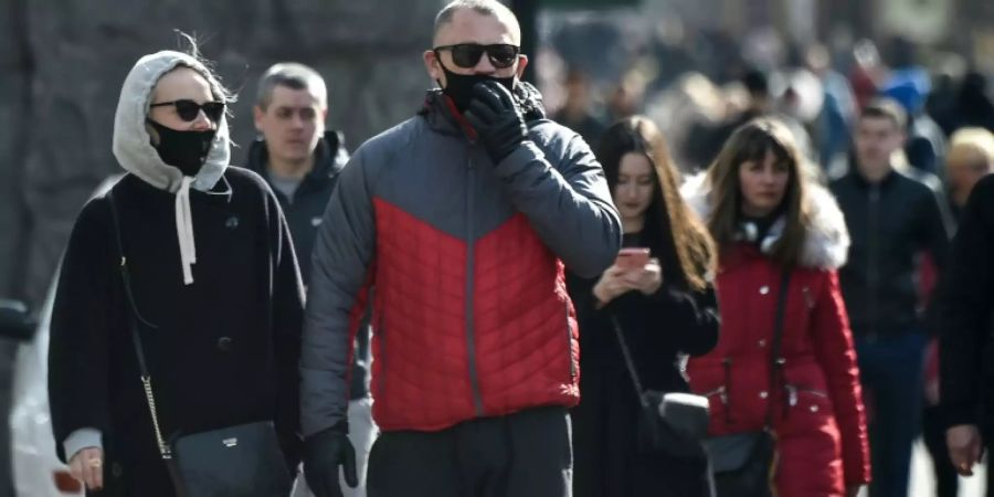 Menschen mit Atemschutzmasken in Kiew