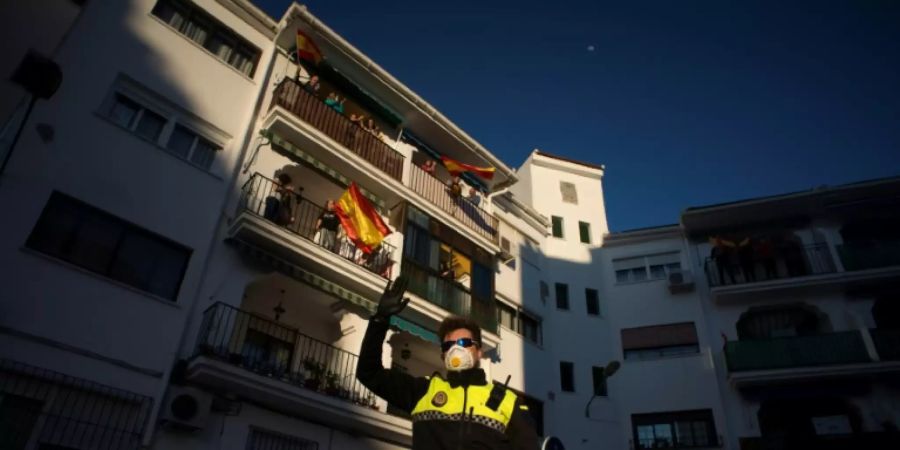 Polizist winkt Menschen in Ronda in ihren Häusern zu