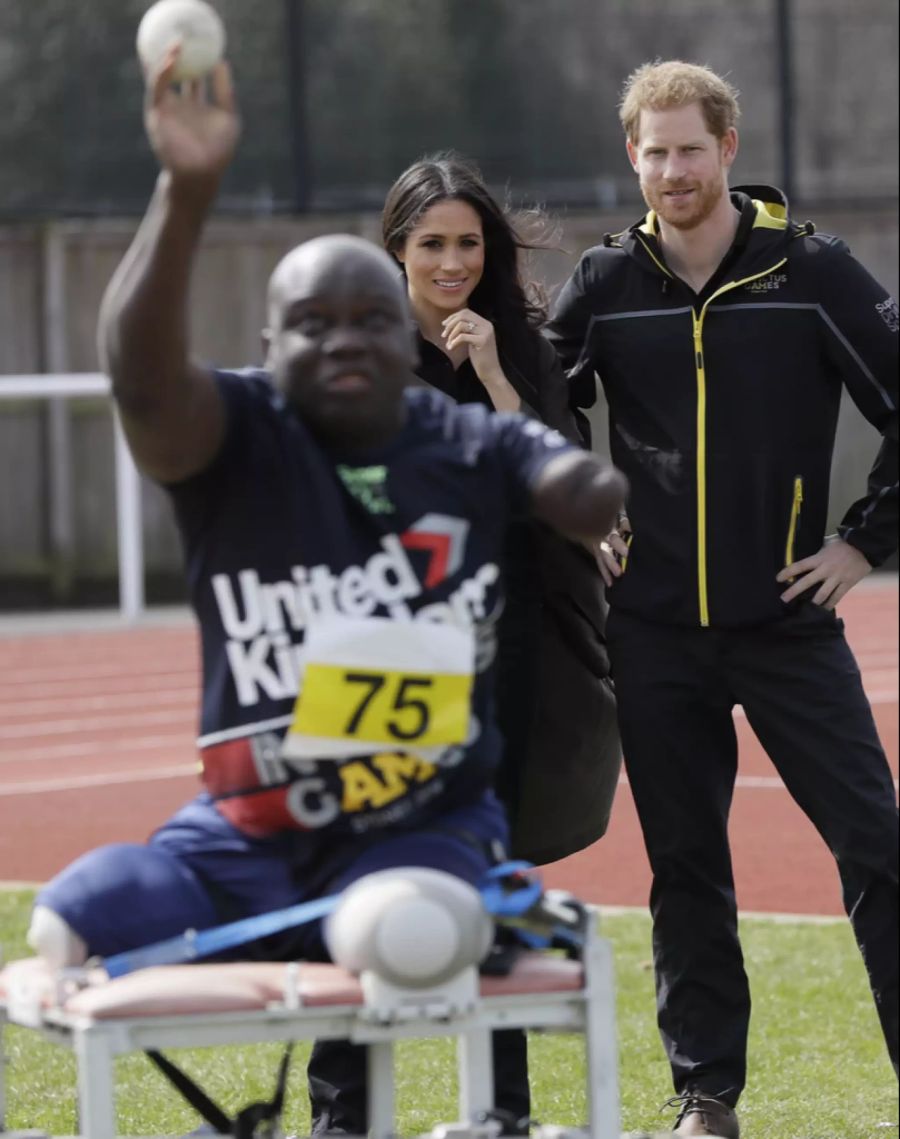 Prinz Harry und Meghan Markle schauen einem Invictus-Sportler zu.