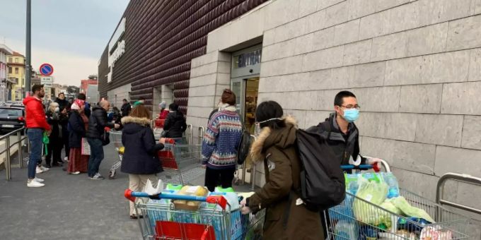 Menschen mit Atemschutzmasken bei einem Supermarkt in Mailand. italien sperrgebiet