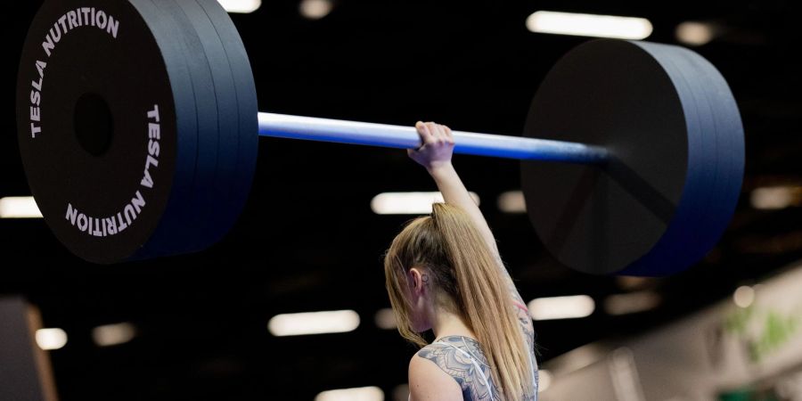 Eine Besucherin hebt an einem Messestand auf der Fitnessmesse Fibo eine Hantel aus Styropor hoch. Die Fibo ist die nach eigenen Angaben weltgrösste Messe für Fitness, Wellness und Gesundheit.