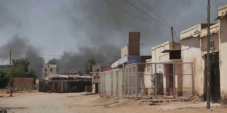 Rauch steigt hinter Gebäuden in Khartum auf. Viele Menschen sind auf der Flucht vor dem Konflikt im Sudan zwischen dem Militär und einer rivalisierenden paramilitärischen Kraft. Foto: Marwan Ali/AP/dpa