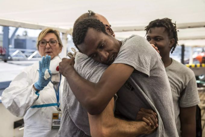 Ein Migrant bedankt sich bei einem Flüchtlingshelfer. libyen
