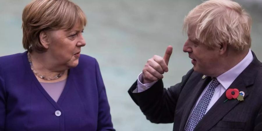 Boris Johnson (r) hat Angela Merkel in einem Gastbeitrag für «Bild» gewürdigt. Foto: Oliver Weiken/dpa