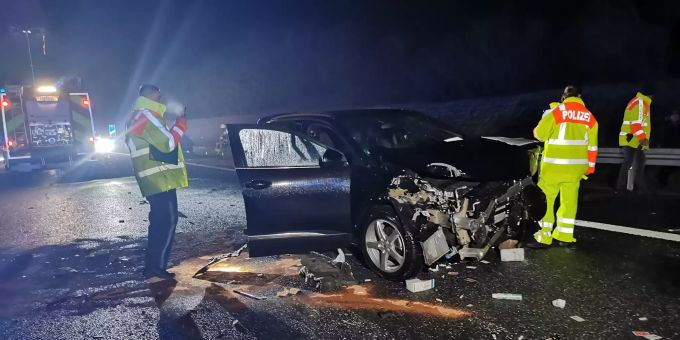 Einsatzkräfte der Polizei stehen neben einem zerstörten Auto auf der Autobahn 6 (A6). A6