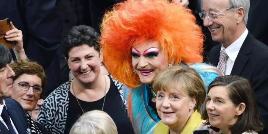 Bundeskanzlerin Angela Merkel (CDU, 2.v.r.) und Dragqueen Olivia Jones (M). Foto: Gregor Fischer/dpa/Archivbild