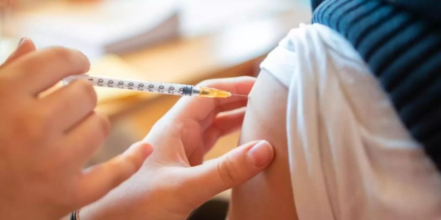 Ein Schüler bekommt eine Impfspritze in den Arm. Foto: Christian Modla/ZB/dpa