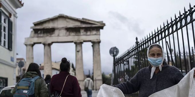 Eine Frau mit Mund-Nasen-Schutz verkauft eine Decke vor dem Tor der antiken römischen Agora in Plaka, einem Stadtteil von Athen. Die griechische Gesundheitsbehörde hat von Montag auf Dienstag 21 657 Corona-Neuinfektionen registriert. Foto: Petros Giannakouris/AP/dpa Eine Frau mit Mund-Nasen-Schutz verkauft eine Decke vor dem Tor der antiken römischen Agora in Plaka, einem Stadtteil von Athen. Die griechische Gesundheitsbehörde hat von Montag auf Dienstag 21 657 Corona-Neuinfektionen registriert. Foto: Petros Giannakouris/AP/dpa