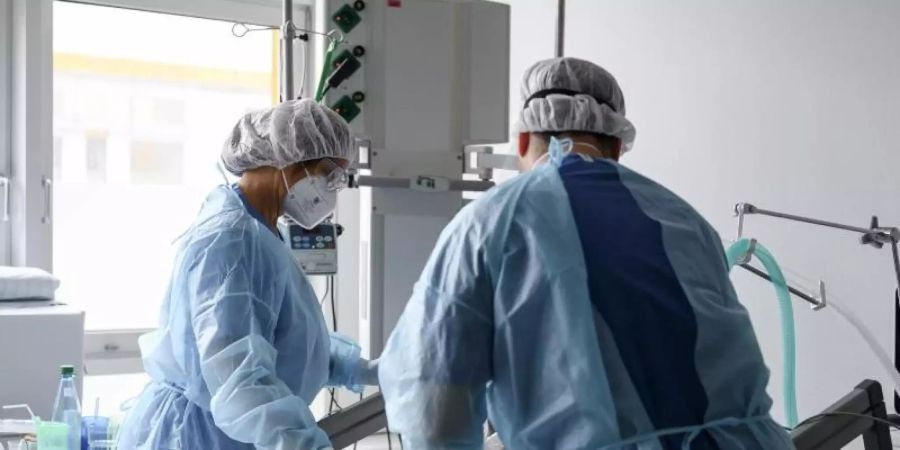 Die pflegerische Leitung einer Intensivstation untersucht einen Corona-Patienten auf der Intensivstation. (Archivbild). Foto: Daniel Vogl/dpa