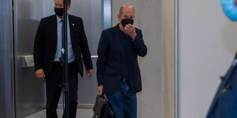 SPD-Kanzlerkandidat Olaf Scholz (M) muss die Sondierungsgespräche am Mittwoch und Donnerstag unterbrechen, weil er zum Treffen der G20-Finanzminister nach Washington reist. Foto: Christophe Gateau/dpa