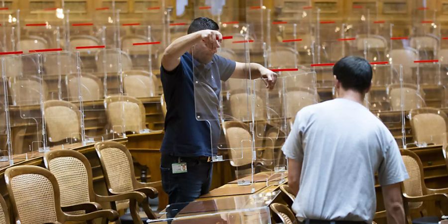 Weil im Parlament die Zertifikatspflicht gilt, räumen Mitarbeiter der Parlamentsdienste die Plexiglasscheiben im Nationalrat weg.