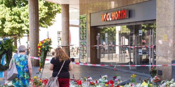Trauerkerzen und Blumen liegen vor dem Kaufhaus, in dem der Täter Menschen mit einem Messer attackiert hatte. Foto: Nicolas Armer/dpa Trauerkerzen und Blumen liegen vor dem Kaufhaus, in dem der Täter Menschen mit einem Messer attackiert hatte. Foto: Nicolas Armer/dpa