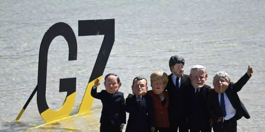 Extinction-Rebellion-Aktivisten mit Masken der Chefs der G7-Gruppe