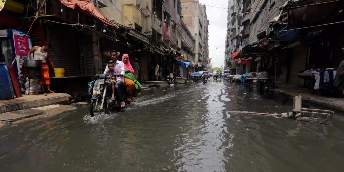 In Pakistan fährt ein Motorradfahrerdurch eine von starken Regenfällen überschwemmte Strasse. Pakistan