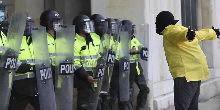 Ein Demonstrant steht während eines Protests gegen die Regierung vor Polizisten. Foto: Fernando Vergara/AP/dpa