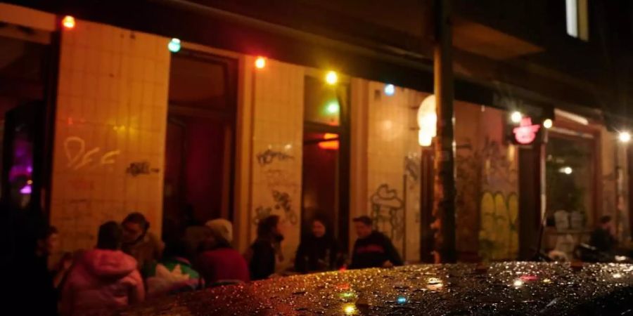 Kurz nach der Sperrstunde sind noch Gäste vor einer Bar in Neukölln. Foto: Annette Riedl/dpa