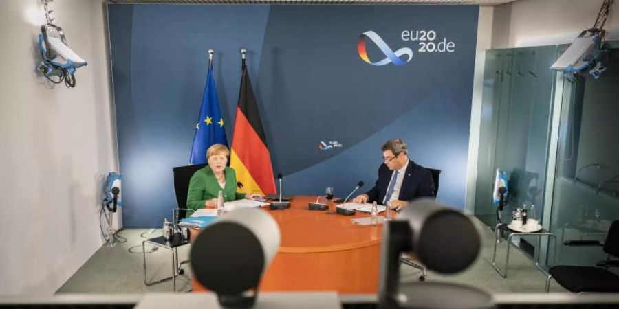 Bundeskanzlerin Angela Merkel (l) und Markus Söder bei der Videokonferenz mit Länderregierungschefs. Foto: Steffen Kugler/Bundesregierung/dpa