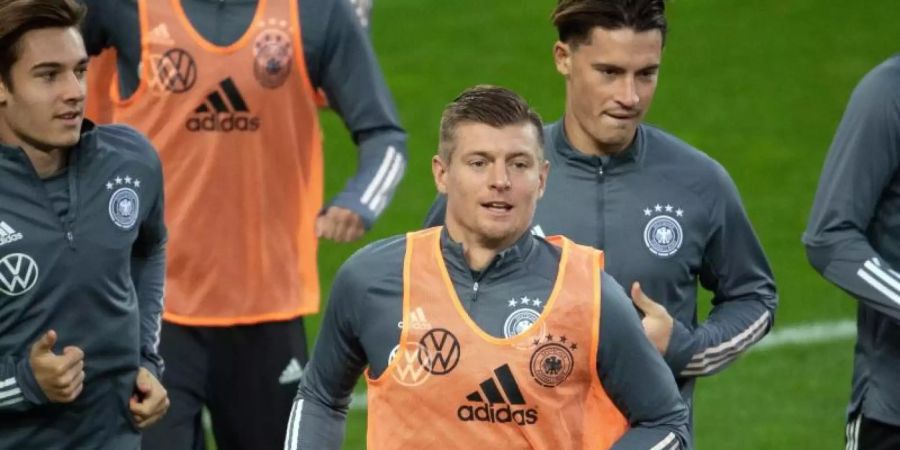 Toni Kroos (M.) wird sein 100. Länderspiel absolvieren. Foto: Federico Gambarini/dpa