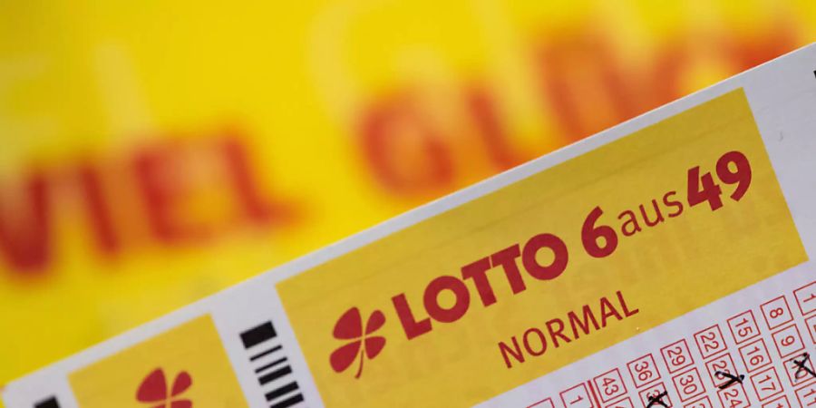 SYMBOLBILD - Ein Lottoschein mit der Aufschrift «Lotto 6 aus 49» ist vor einem Schriftzug «Viel Glück» zu sehen. Foto: Swen Pförtner/dpa