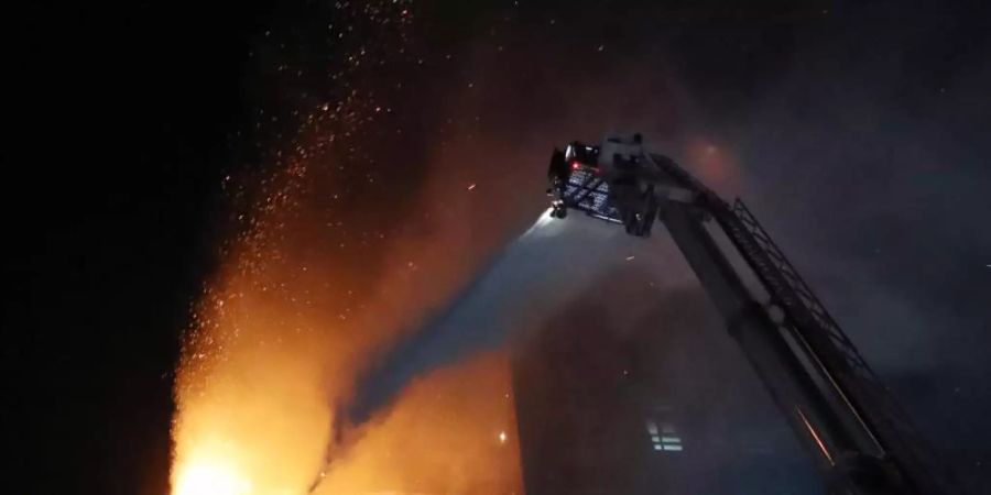 Feuerwehrleute versuchen, den Brand in einem Hochhaus zu löschen. Foto: -/YNA/dpa